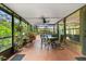 Enclosed patio with dining area, lush plants, and a view of the outdoor pool at 1247 Rosemary Dr, Orlando, FL 32807