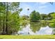 Scenic pond view with lush greenery, mature trees, and serene water reflecting the sky for a tranquil outdoor escape at 1247 Rosemary Dr, Orlando, FL 32807