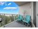 Balcony with stylish seating, lake view, white metal railing and blue chairs at 13427 Blue Heron Beach Dr # 306, Orlando, FL 32821