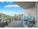 Balcony with stylish seating, lake view and white metal railing at 13427 Blue Heron Beach Dr # 306, Orlando, FL 32821