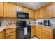 Well-equipped kitchen features granite countertops and a suite of black appliances and wooden cabinetry at 13427 Blue Heron Beach Dr # 306, Orlando, FL 32821