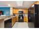 Open kitchen featuring wooden cabinets, granite countertops, and modern black appliances at 13427 Blue Heron Beach Dr # 306, Orlando, FL 32821