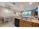 Open concept kitchen with granite countertops, stainless sink, and open access to the living area and balcony at 13427 Blue Heron Beach Dr # 306, Orlando, FL 32821
