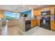 Open kitchen with breakfast bar, wooden cabinets, and black appliances overlooking the living area at 13427 Blue Heron Beach Dr # 306, Orlando, FL 32821