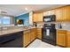 Bright kitchen with wood cabinets and black appliances, connecting to living area and scenic views at 13427 Blue Heron Beach Dr # 306, Orlando, FL 32821