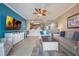 Open-concept living area with blue accent wall, ceiling fan, and access to kitchen and dining at 13427 Blue Heron Beach Dr # 306, Orlando, FL 32821