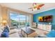 Stylish living room with a ceiling fan, balcony access, a blue accent wall, and comfortable neutral seating at 13427 Blue Heron Beach Dr # 306, Orlando, FL 32821