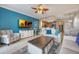 Bright living room with coastal decor, a ceiling fan, and an open floor plan to the kitchen at 13427 Blue Heron Beach Dr # 306, Orlando, FL 32821