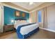 Bright main bedroom featuring blue accent wall, nightstands, ceiling fan, and a window at 13427 Blue Heron Beach Dr # 306, Orlando, FL 32821