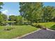 Green backyard features manicured lawn, brick-paved area, pond and mature trees, perfect for outdoor relaxation at 1386 Longley Pl, Deland, FL 32724