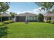 Well-maintained backyard featuring lush lawn, elegant landscaping, and a screened porch for outdoor enjoyment at 1386 Longley Pl, Deland, FL 32724