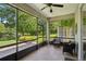 Relaxing screened porch with tile flooring, ceiling fan, and serene views of the pond at 1386 Longley Pl, Deland, FL 32724