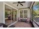 Cozy screened porch featuring tile flooring, ceiling fan, and comfortable seating area at 1386 Longley Pl, Deland, FL 32724