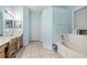 Bright blue bathroom boasts a soaking tub, vanity with sink, and tiled floor at 140 Rangeline Woods Cv, Longwood, FL 32750