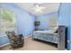 Serene bedroom with ample natural light, ceiling fan, and a comfortable seating area at 140 Rangeline Woods Cv, Longwood, FL 32750