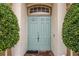 Inviting light blue double front doors are framed by symmetrical greenery and light neutral pillars on brick entryway at 140 Rangeline Woods Cv, Longwood, FL 32750