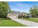 Wide shot showing this home's driveway, landscaping, and large garage that complements its neutral-toned stucco exterior at 140 Rangeline Woods Cv, Longwood, FL 32750