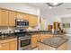 Well-equipped kitchen features stainless steel appliances, granite countertops, and ample cabinetry at 140 Rangeline Woods Cv, Longwood, FL 32750