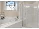 Bright bathroom featuring a soaking tub with window and a glass-enclosed shower at 14174 Islamorada Dr, Orlando, FL 32837