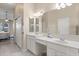 Bathroom with dual sinks, ample lighting, and a doorway to a bedroom at 14174 Islamorada Dr, Orlando, FL 32837