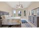 Primary bedroom with tray ceiling, ceiling fan, three large windows, and an en suite bathroom at 14174 Islamorada Dr, Orlando, FL 32837