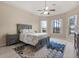 Comfortable bedroom with tray ceiling, ceiling fan, two large windows, and an en suite bathroom at 14174 Islamorada Dr, Orlando, FL 32837