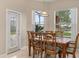 Dining area with wood table, pendant lighting, and a view of the screened-in pool area and backyard at 14174 Islamorada Dr, Orlando, FL 32837