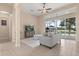 Comfortable living room with neutral tones, a ceiling fan, a gray sofa, and sliding glass doors to the pool area at 14174 Islamorada Dr, Orlando, FL 32837