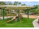 ' playground featuring a slide, climbing equipment, and shaded seating with views of mature trees at 14174 Islamorada Dr, Orlando, FL 32837