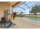 Relaxing screened-in pool area with lounge chairs and view of the backyard and lake at 14174 Islamorada Dr, Orlando, FL 32837