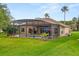 Back of the house featuring a screened-in pool area, patio, and well-maintained lawn at 14174 Islamorada Dr, Orlando, FL 32837