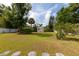 Lush backyard featuring mature trees, green grass, and a small storage shed at 1418 Oregon St, Orlando, FL 32803
