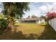 View of the rear of the house showing an enclosed porch and a spacious, grassy backyard at 1418 Oregon St, Orlando, FL 32803