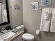 Well-lit bathroom showcasing a granite countertop vanity, toilet, and decorative wall art at 1428 Casterton Cir, Davenport, FL 33897