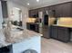 Modern kitchen with stainless steel appliances, gray cabinets, and granite countertops, flowing into the dining area at 1428 Casterton Cir, Davenport, FL 33897