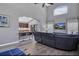 Cozy living room featuring vaulted ceilings, wood floors, a large TV, and open flow into the kitchen at 1428 Casterton Cir, Davenport, FL 33897