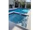 Inviting backyard with a refreshing pool, relaxing spa, and stylish screened enclosure at 1428 Casterton Cir, Davenport, FL 33897