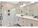 Modern bathroom with a glass enclosed shower with marble tile and a double sink vanity at 1461 Santorini Way, Tavares, FL 32778