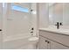 Bathroom featuring white herringbone tile in shower, gray vanity with dark hardware, and a mirror at 1461 Santorini Way, Tavares, FL 32778