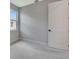 Bedroom featuring neutral carpet, a window, and white door with black hardware at 1461 Santorini Way, Tavares, FL 32778
