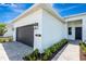 Contemporary home featuring a sleek design, a paved driveway, and lush landscaping at 1461 Santorini Way, Tavares, FL 32778