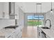 Modern kitchen with stainless steel appliances, bright white cabinets, and sliding glass doors at 1461 Santorini Way, Tavares, FL 32778