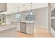 Kitchen area with white center island, stainless steel dishwasher and views to a living space at 1461 Santorini Way, Tavares, FL 32778