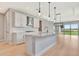 Open-concept kitchen featuring a center island, stainless steel appliances, and bright cabinets at 1461 Santorini Way, Tavares, FL 32778