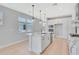 Bright kitchen features a center island with marble countertop, pendant lighting and stainless steel appliances at 1461 Santorini Way, Tavares, FL 32778