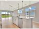 Bright, open kitchen featuring a center island, hardwood floors, and modern pendant lighting at 1461 Santorini Way, Tavares, FL 32778
