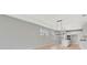 Open living space featuring hardwood floors, white cabinets, an island, and a modern light fixture at 1461 Santorini Way, Tavares, FL 32778