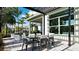 Outdoor dining area with shade, surrounded by lush greenery and beautiful landscaping for an inviting atmosphere at 1461 Santorini Way, Tavares, FL 32778