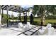 Outdoor living area with shade, modern seating, and manicured landscaping, perfect for relaxing and entertaining at 1461 Santorini Way, Tavares, FL 32778