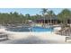 Resort-style pool with lounge chairs, palm trees, and ample space for relaxation and recreation at 1461 Santorini Way, Tavares, FL 32778
